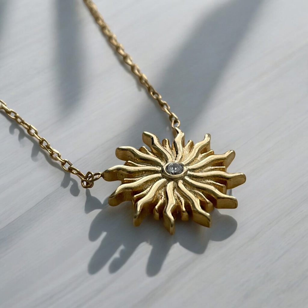 Add a touch of radiance to your outfit with our Sun Necklace. Made with 14ct gold plated sterling silver and a sparkling zirconia stone