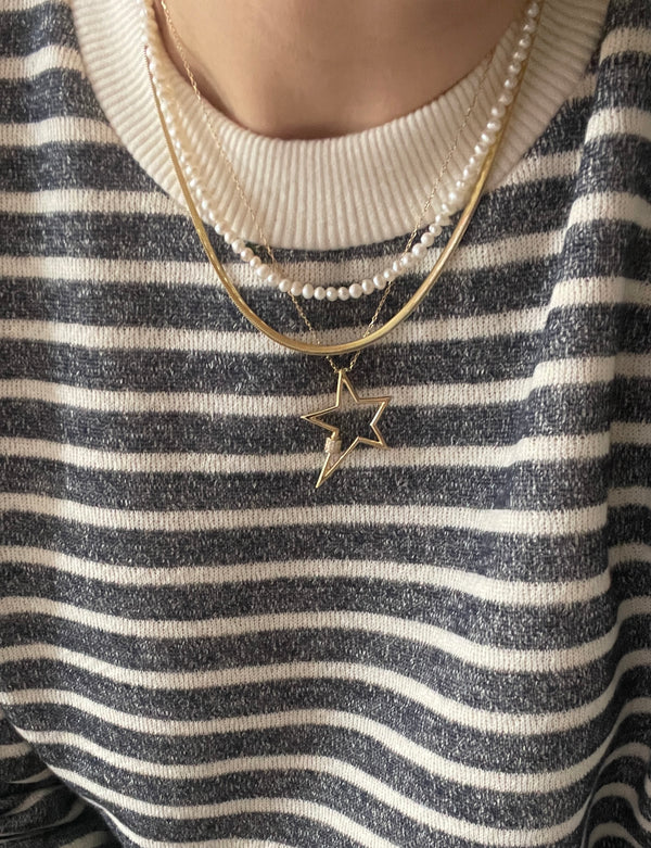 Shine like a star with our quirky, one-of-a-kind Star Necklace! Its irregular shape and dazzling zirconia stones add a touch of fun and playfulness to any outfit. Made of 14ct gold and sterling silver, it's a must-have piece for your jewellery collection.
